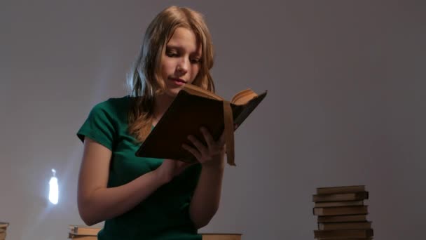 Κορίτσι περιβάλλεται από βιβλία και ανάγνωση. 4k Uhd. — Αρχείο Βίντεο