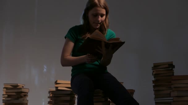 Chica adolescente está rodeada de libros y lectura. 4K UHD . — Vídeos de Stock