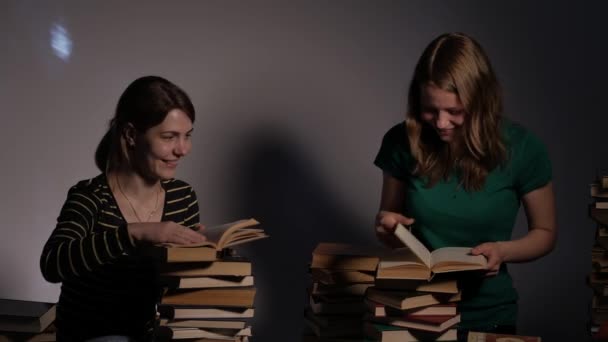 Twee meisje, moeder en haar tiener dochter, of twee zussen zijn het lezen van boeken en plezier maken met boeken. 4k Uhd. — Stockvideo