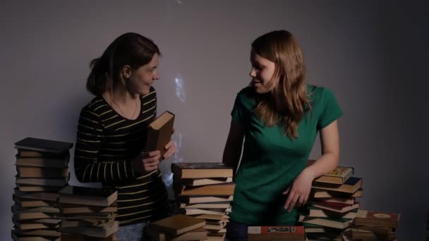 Twee meisje, moeder en haar tiener dochter, of twee zussen zijn het lezen van boeken en plezier maken met boeken. 4k Uhd. — Stockvideo