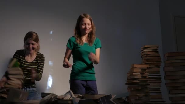 Dos niñas, su madre y su hija adolescente, o dos hermanas están leyendo libros y divirtiéndose con libros. 4K UHD . — Vídeos de Stock