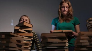 İki kız, anne ve genç kızı ya da iki kız kardeş kitap okuma ve kitap ile eğleniyor. 4k Uhd.