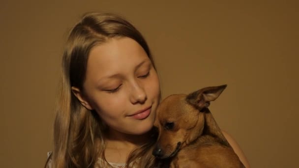 Sorrindo menina adolescente se divertindo com seu pequeno brinquedo terrier cachorrinho. 4K UHD . — Vídeo de Stock