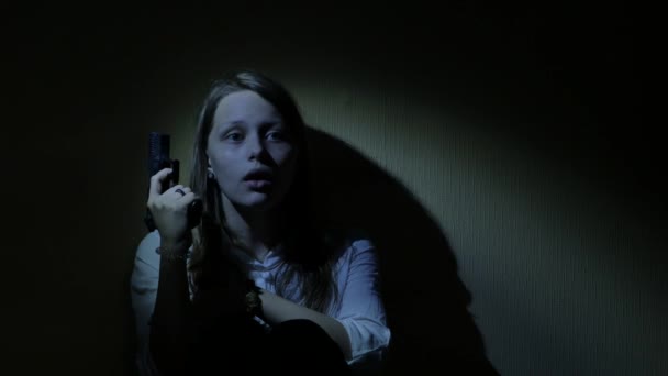 Φοβάται έφηβος κορίτσι με ένα πυροβόλο όπλο σε ένα σκοτεινό. 4k Uhd. — Αρχείο Βίντεο