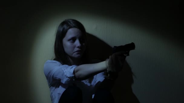 Uma adolescente assustada com uma arma no escuro. 4K UHD . — Vídeo de Stock