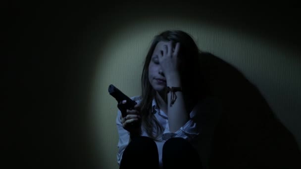 Испуганная девочка-подросток с пистолетом в темноте. 4K UHD . — стоковое видео