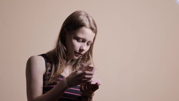 Όμορφη έφηβος κορίτσι ανοίγει ένα κουτί δώρου. 4k Uhd — Αρχείο Βίντεο