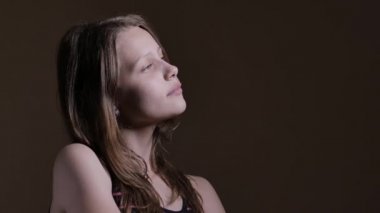 Düşünceli oturan ve gülümseyen genç kız. Rüya hakkında bir şey. 4k Uhd.