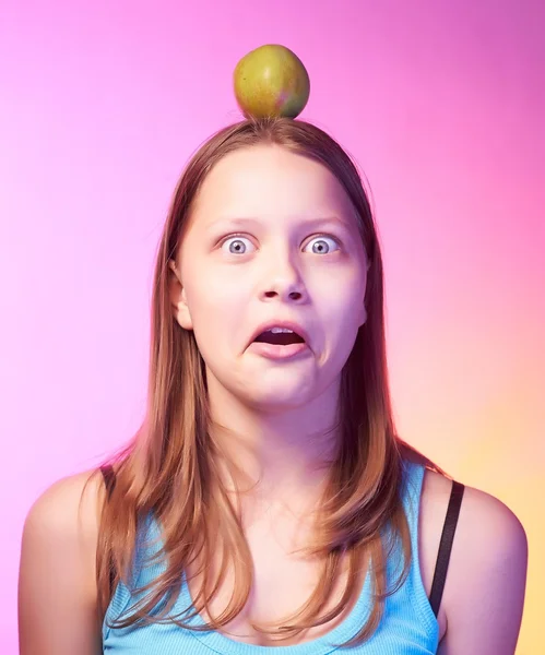 Teen girl holding an apple on her head as a target — Stock Photo, Image