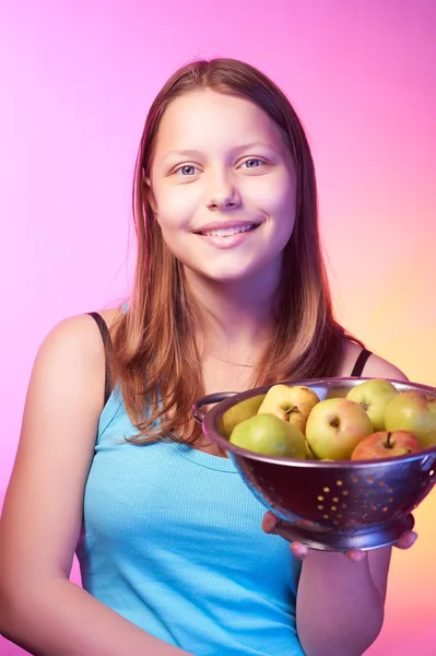 Adolescente chica sosteniendo un colador lleno de manzanas — Foto de Stock