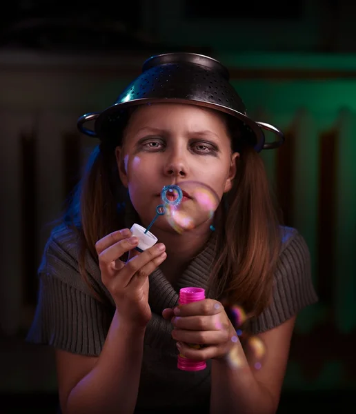Triest tiener meisje zit en blaast zeepbellen — Stockfoto