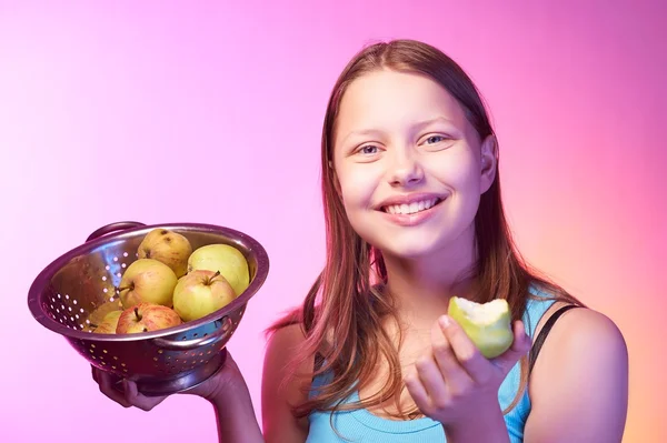 Adolescente chica sosteniendo un colador lleno de manzanas — Foto de Stock