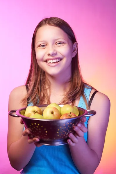 Teenie-Mädchen mit einem Sieb voller Äpfel — Stockfoto