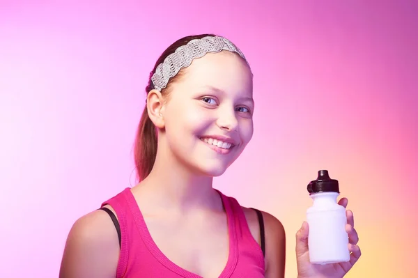Adolescente chica sostiene botella con agua y sonriendo — Foto de Stock