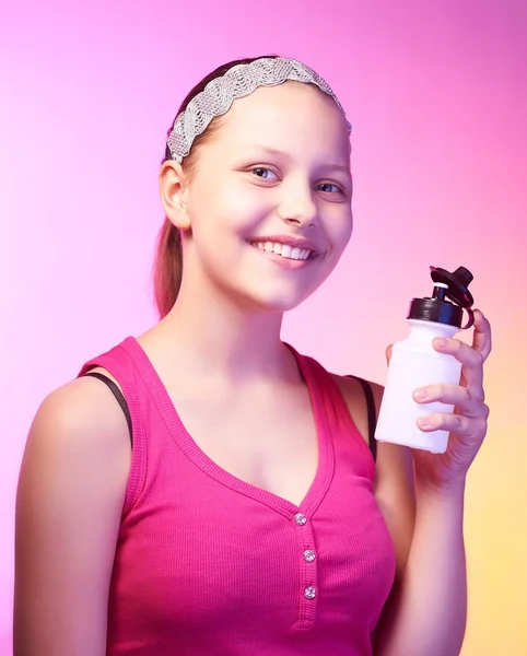 Tiener meisje houdt fles met water en glimlachen — Stockfoto