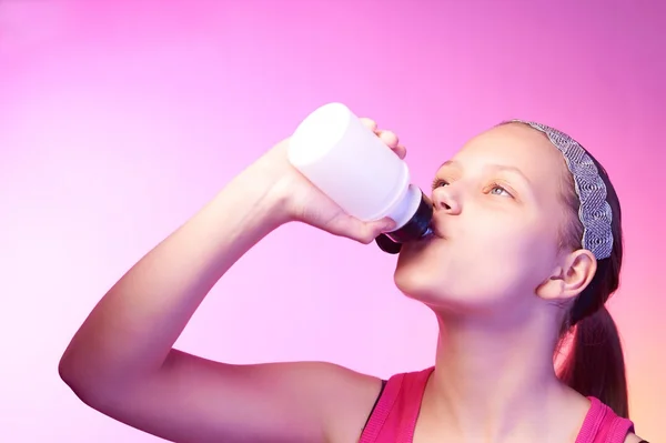 Teen girl drinks water from bottle after long running — Stock Photo, Image