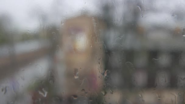 Abstrato borrões de luzes e gotas de chuva pela janela — Vídeo de Stock