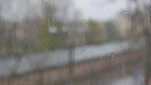 Soyut ışıkları bulanıklaştırır ve pencereden yağmur damlaları — Stok video