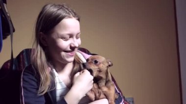 Genç kız ile bir küçük köpecik. Oynama ve alay.