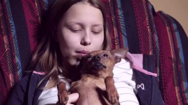 Genç kız ile bir küçük köpecik. Oynama ve alay.