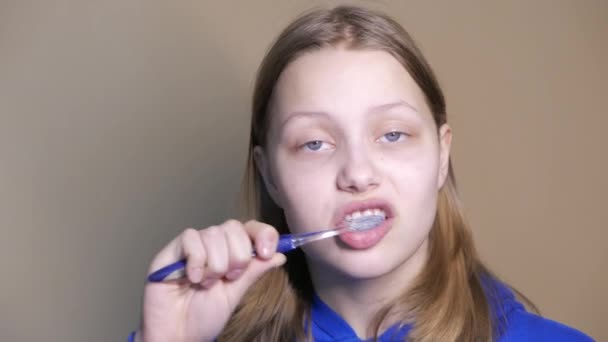 Unhappy teen girl brushing teeth — Stock Video