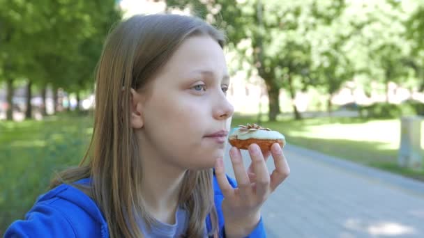 Adolescente chica comer un donut — Vídeos de Stock