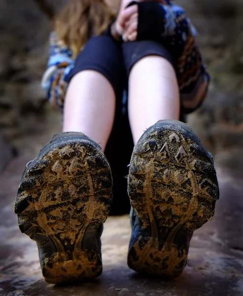 Chica senderismo botas barro sentado en roca —  Fotos de Stock