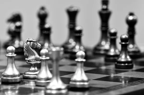 Tabuleiro de xadrez com cavaleiro enfrentando opositor — Fotografia de Stock