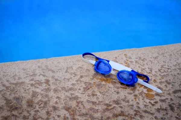 Óculos de banho azuis ao lado da piscina — Fotografia de Stock