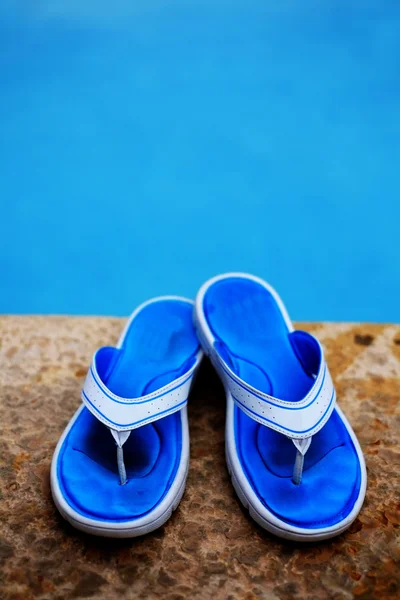 Chanclas azules junto a la piscina — Foto de Stock