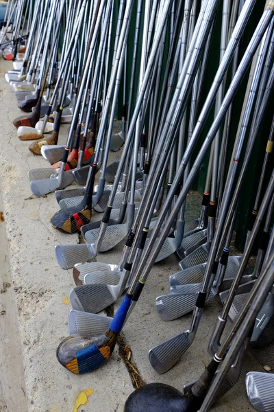 Fila de muitos velhos clubes de golfe usados para o esporte — Fotografia de Stock