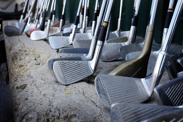 Fila de muitos velhos clubes de golfe usados para o esporte — Fotografia de Stock
