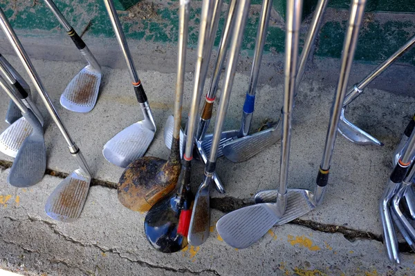 Fila de muitos velhos clubes de golfe usados para o esporte — Fotografia de Stock