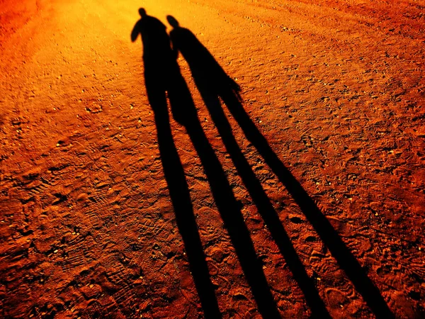 Sombra Duas Pessoas Mãos Dadas Andando Por Uma Estrada Terra — Fotografia de Stock