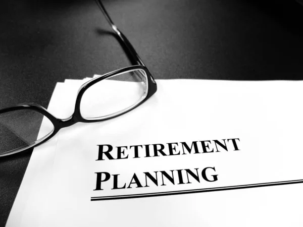 退休计划文件放在桌上 并配戴眼镜 以备退休计划之用 — 图库照片