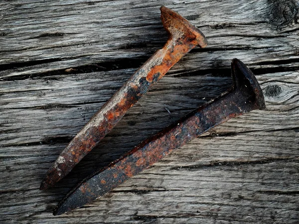 木材表面上の古い錆びた鉄の鉄道のスパイク — ストック写真