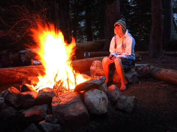 Flicka bara vid lägerelden medan camping — Stockfoto