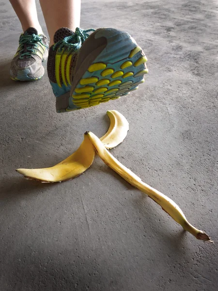 バナナの皮を踏んで滑る人の詳細 — ストック写真