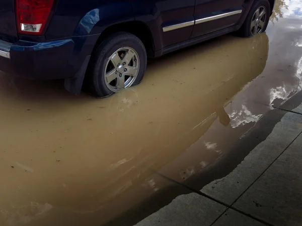 Bil som kör genom översvämning vatten — Stockfoto