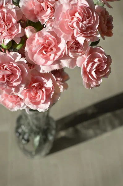 Cravos cor-de-rosa em madeira velha e vaso — Fotografia de Stock