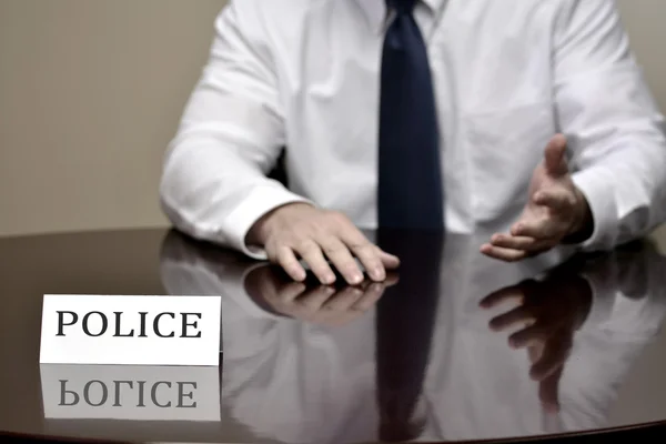 Polizei am Schreibtisch mit Namensschild — Stockfoto