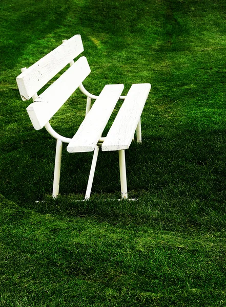 Linhas de bancos de parque branco para sentar-se na grama verde — Fotografia de Stock