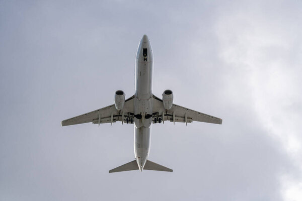 Underside of an airplane on white sky