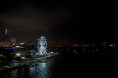 Bayside Pazarı 'ndaki Miami Skyview dönme dolabındaki gece manzarası suda yansıyor.