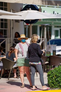 Miami Beach, FL, ABD - 30 Ocak 2021: Uber Lyft 'e binmeyi bekleyen kadınlar
