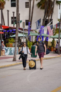 Miami Beach, FL, ABD - 30 Ocak 2021: Airbnb turistleri Miami Beach 'te ellerinde bir davayla geziyorlar.