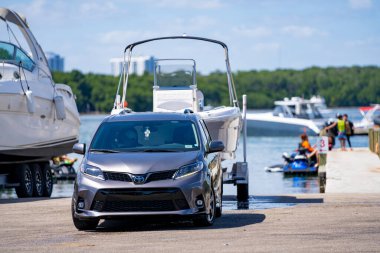 Miami Beach, FL, USA - March 13, 2021: Toyota Sienna towing a boat at the Haulover Marina Miami Beach FL clipart