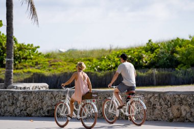 Ocean Drive 2021 'de Miami Plajı' nda bisiklete binen çift.