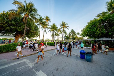 Miami Beach, FL, ABD - 26 Mart 2021: Polisin sokağa çıkma yasağı yaklaşırken Miami Beach 'te bahar tatili kalabalığı. Ocean Drive ve Lummus Park alanları