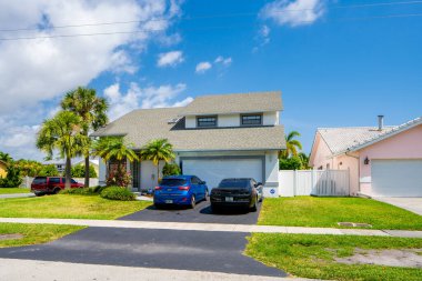 Yeşil çimen ve mavi gökyüzü olan modern bir ev.